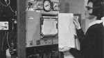 A woman reading a printout on an early mainframe computer